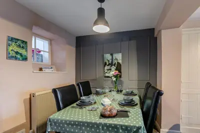 a dining room table with a green tablecloth and black chairs at 2 Bed in Field Broughton oc-l31021 in Cartmel