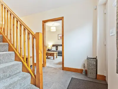 a hallway with stairs leading to a living room at Tower Cottage in Arnside
