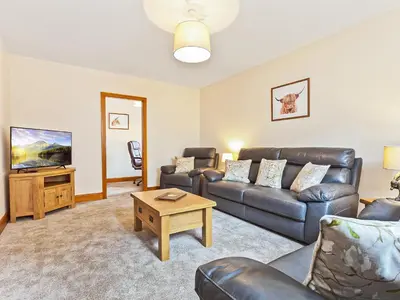 a living room with a couch and a table at Pier Cottage in Arnside