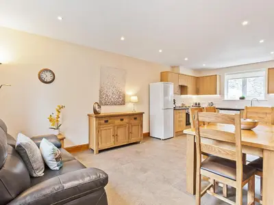a kitchen and living room with a couch and a table at Pier Cottage in Arnside
