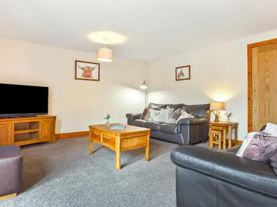a living room with a couch and a tv at Hollins Cottage in Silverdale