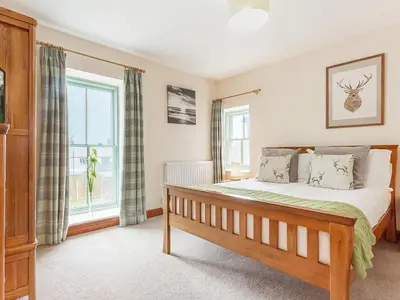 a bedroom with a bed and two windows at The Pepperpot - Uk49156 in Silverdale
