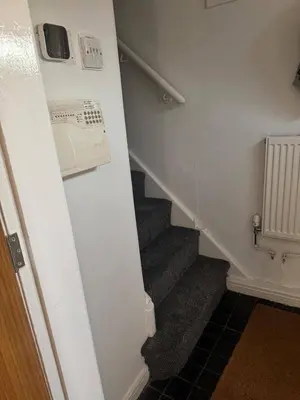a hallway with a staircase with a phone on the wall at Knotty Ash - 3 Beds - Sleeps 6 - On-Site Parking in Liverpool