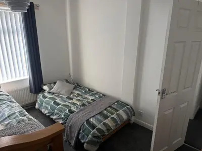 a small bedroom with a bed and a window at Knotty Ash - 3 Beds - Sleeps 6 - On-Site Parking in Liverpool