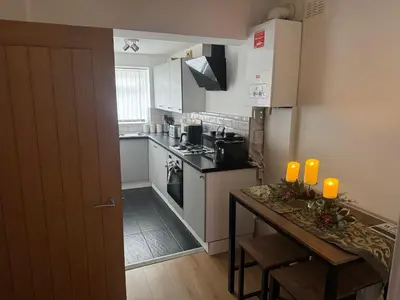 a kitchen with a counter and a table with orange candles at Knotty Ash - 3 Beds - Sleeps 6 - On-Site Parking in Liverpool
