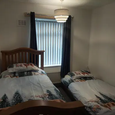 a bedroom with two twin beds and a window at Knotty Ash - 3 Beds - Sleeps 6 - On-Site Parking in Liverpool