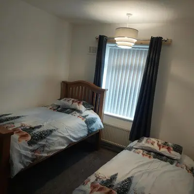 a bedroom with two twin beds and a window at Knotty Ash - 3 Beds - Sleeps 6 - On-Site Parking in Liverpool