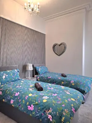 a bedroom with two beds and a heart on the wall at Amazing Central House in Blackpool