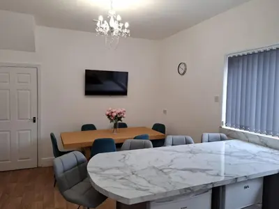 a dining room with a marble table and chairs at Amazing Central House in Blackpool