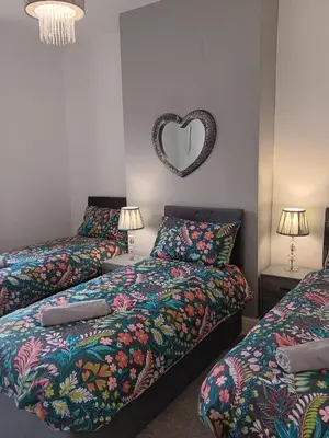 a bedroom with two beds and a heart mirror at Amazing Central House in Blackpool