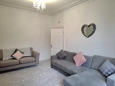 a living room with two couches and a heart sign on the wall at Amazing Central House in Blackpool