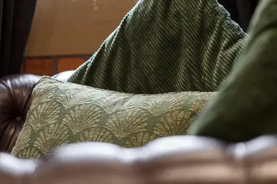 a couch with green pillows on top of it at Charming 4BR House in St Helens - Sleep 8 in Saint Helens