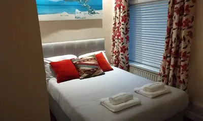 a bed with towels on top of it with a window at Stratford House Holiday Apartments in Blackpool