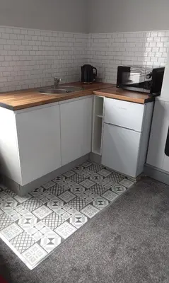 a kitchen with a counter and a tile floor at Stratford House Holiday Apartments in Blackpool