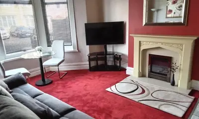 a living room with a couch and a fireplace at Stratford House Holiday Apartments in Blackpool