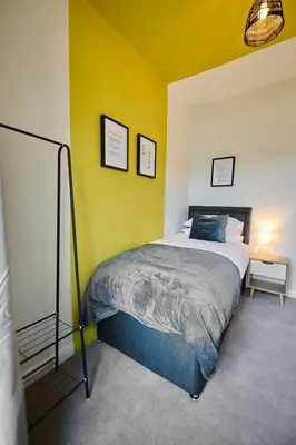 a bedroom with a bed and a yellow wall at 2 Bedroom House- Contractors - Families - Sleeps 4 in Great Harwood