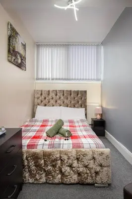 a bedroom with a large bed with a checkered blanket at The Ocean Inn in Blackpool