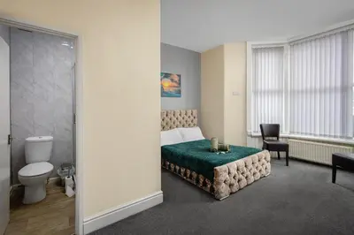 a bedroom with a bed and a bathroom with a toilet at The Ocean Inn in Blackpool