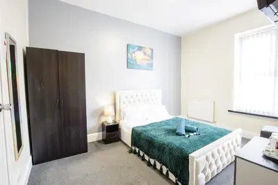 a white bedroom with a bed and a window at The Ocean Inn in Blackpool
