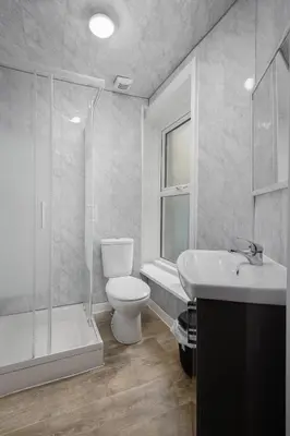 a bathroom with a toilet and a shower and a sink at The Ocean Inn in Blackpool