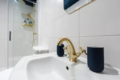 a white bathroom sink with a gold faucet at RST Bramley Boutique in Liverpool