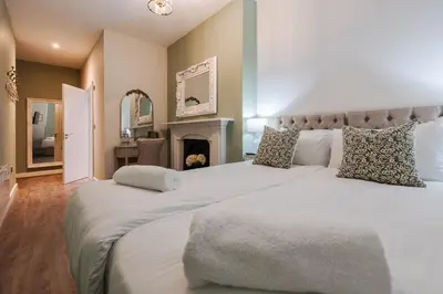 a bedroom with two large white beds and a fireplace at RST Bramley Boutique in Liverpool