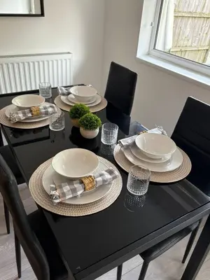 a dining room table with plates and bowls and chairs at Spacious Bungalow in St Helens, 1-Min Drive to Carr Mill Bridge in Saint Helens