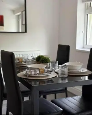 a dining room table with plates and bowls on it at Spacious Bungalow in St Helens, 1-Min Drive to Carr Mill Bridge in Saint Helens
