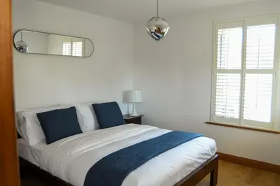 a bedroom with a bed with a mirror on the wall at Foundry View in Millom