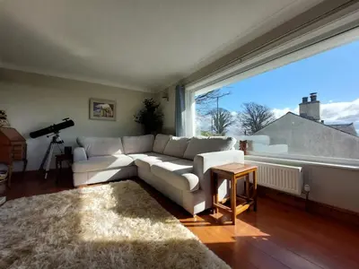 a living room with a white couch and a large window at Seaview home in Baycliff, Cumbria in Baycliff