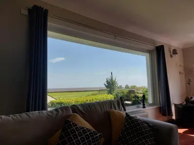 a couch sitting in front of a large window at Seaview home in Baycliff, Cumbria in Baycliff