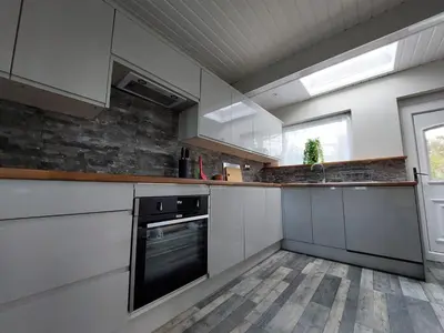 a kitchen with white cabinets and a black oven at Seaview home in Baycliff, Cumbria in Baycliff