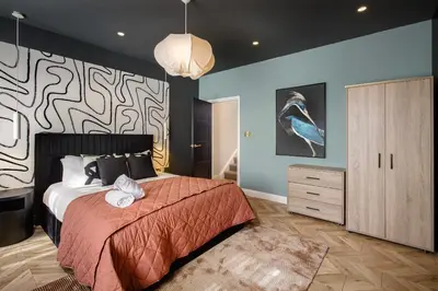 a bedroom with a bed and a wall with a bird on it at Stylish 4-Bed House Central Blackpool Family Stay in Blackpool
