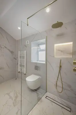 a bathroom with a toilet and a glass shower at Stylish 4-Bed House Central Blackpool Family Stay in Blackpool