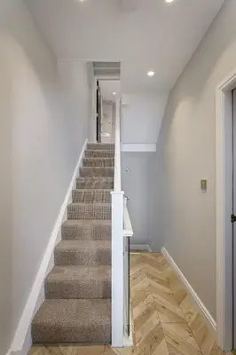 a staircase in a home with white walls and wooden floors at Stylish 4-Bed House Central Blackpool Family Stay in Blackpool