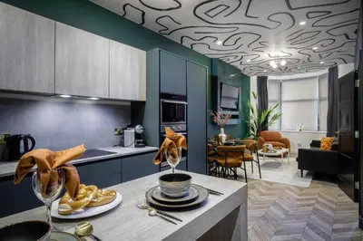 a kitchen and living room with blue cabinets at Stylish 4-Bed House Central Blackpool Family Stay in Blackpool