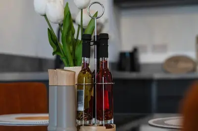 three bottles of wine sitting on a table with flowers at Stylish Luxury Penthouse in Liverpool City Centre - Free Private Parking and Only 2km from Everton Stadium! in Liverpool