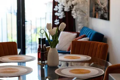 a table with two chairs and a vase with white flowers at Stylish Luxury Penthouse in Liverpool City Centre - Free Private Parking and Only 2km from Everton Stadium! in Liverpool