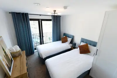 a hotel room with two beds and a balcony at Stylish Luxury Penthouse in Liverpool City Centre - Free Private Parking and Only 2km from Everton Stadium! in Liverpool