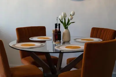 a dining room table with plates and a vase of flowers at Stylish Luxury Penthouse in Liverpool City Centre - Free Private Parking and Only 2km from Everton Stadium! in Liverpool