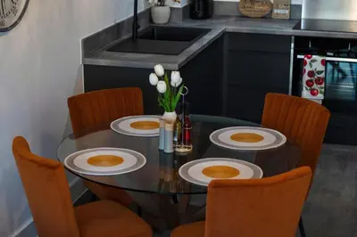 a dining room table with chairs and a table with plates on it at Stylish Luxury Penthouse in Liverpool City Centre - Free Private Parking and Only 2km from Everton Stadium! in Liverpool