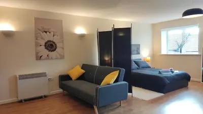 a living room with a couch and a bed at Modern Studio Flat in Wigan in Wigan