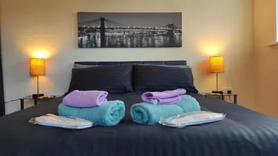 a bed with towels and pillows on top of it at Modern Studio Flat in Wigan in Wigan