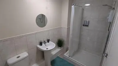 a bathroom with a toilet sink and a shower at Modern Studio Flat in Wigan in Wigan