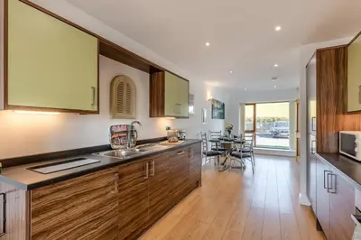 a kitchen with wooden cabinets and a dining room at 2 Bed in Carnforth oc-s31763 in Warton