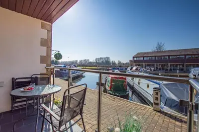 a balcony with a table and chairs next to a marina at 2 Bed in Carnforth oc-s31763 in Warton