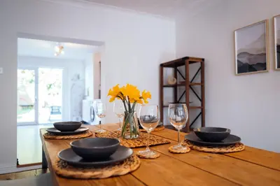 a wooden table with plates and wine glasses on it at Bradley's Hideaway With Private Garden in Eccleston