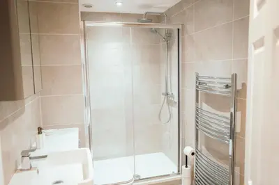 a bathroom with a shower with a glass door at Bradley's Hideaway With Private Garden in Eccleston
