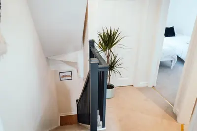 a stairway with a black railing and a plant at Bradley's Hideaway With Private Garden in Eccleston