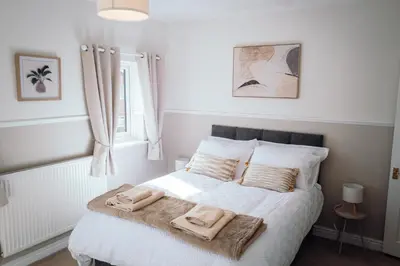 a bedroom with a bed with two towels on it at Bradley's Hideaway With Private Garden in Eccleston